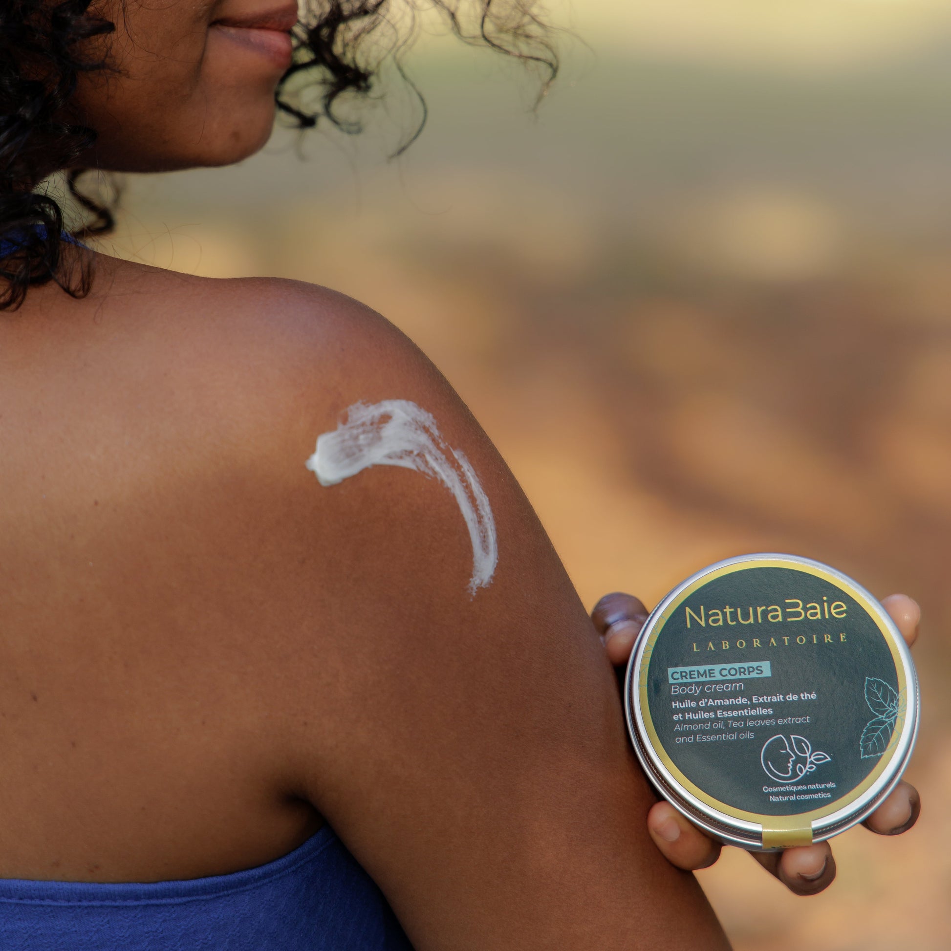 Woman applying NaturaBaie product to her arm outdoors